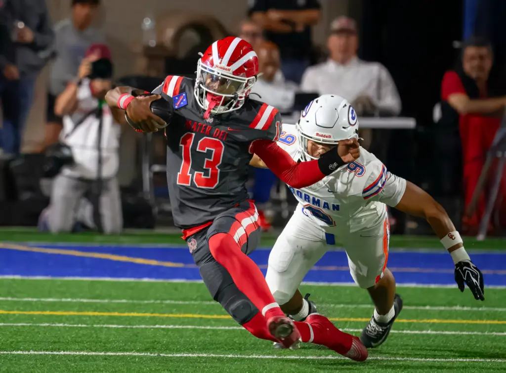 Mater Dei quarterback Paytyn Guess, left, scrambles away from Bishop...