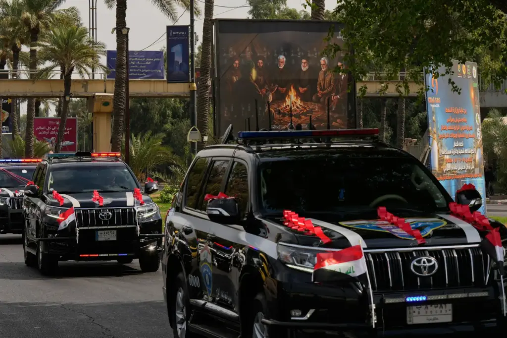 Iraqi security vehicles decorated with national flags and ribbons drive in a convoy.