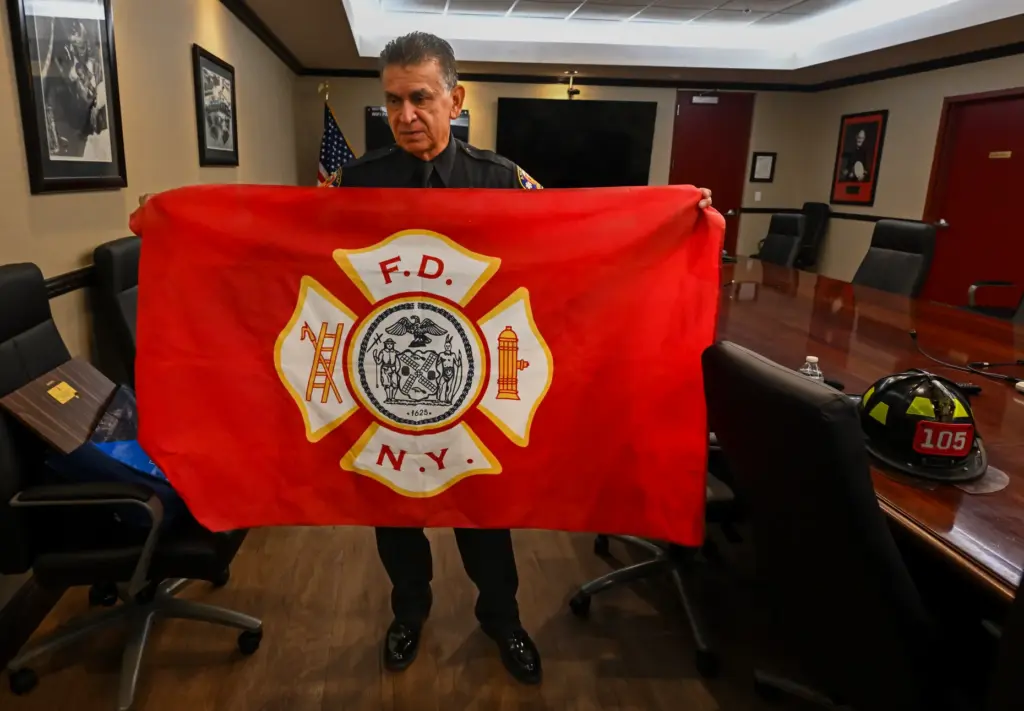 Retired firefighter Fernando Negrete, holding his flag to commemorate an...