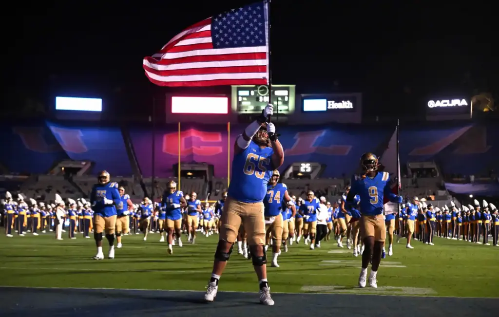 Offensive lineman Hall Schmidt (65) of the UCLA Bruins carries...