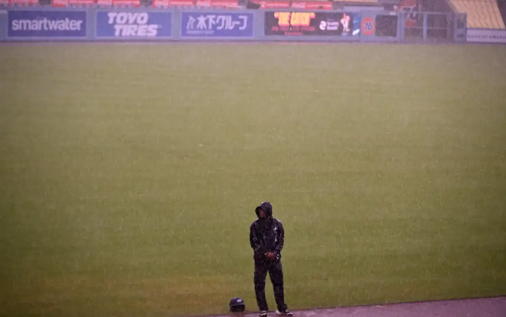 A lone Dodgers security officer stands on the field in...