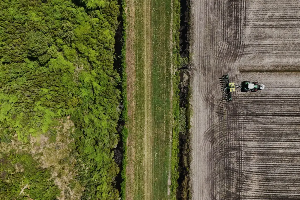 A planter, right, works in a field adjacent to a...