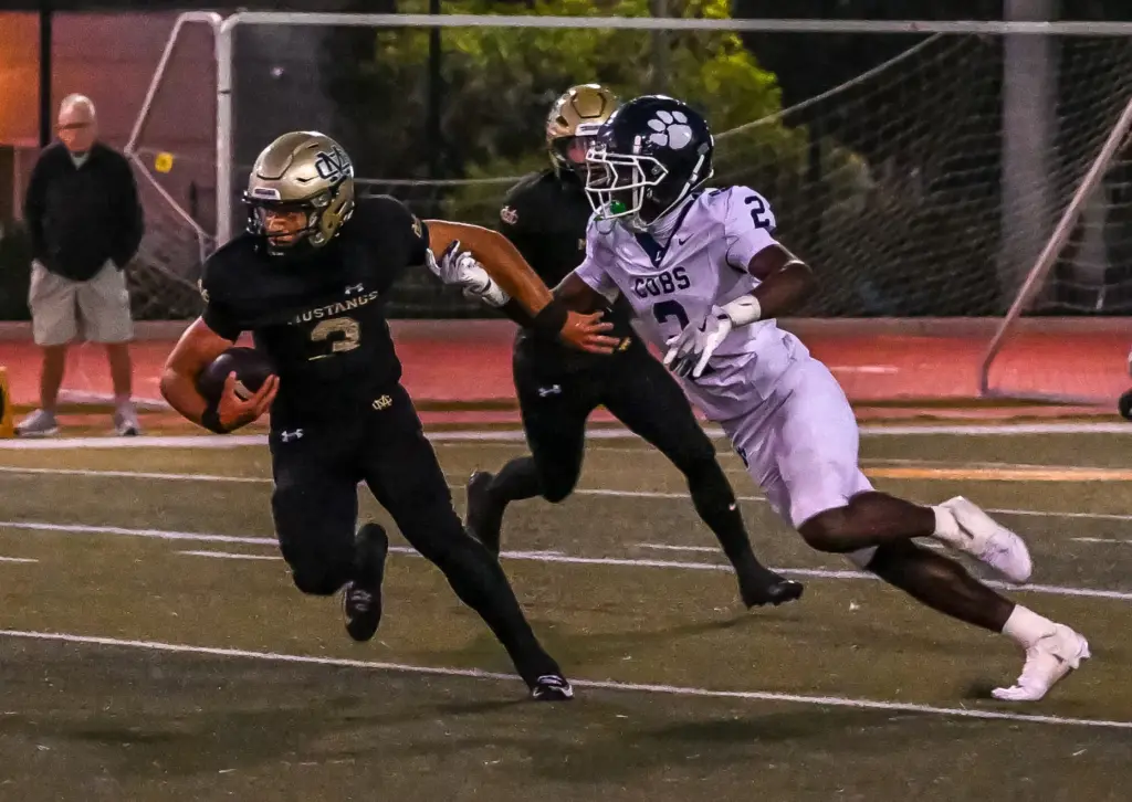 Mira Costa quarterback Wyatt Nucci rushes with the ball during...