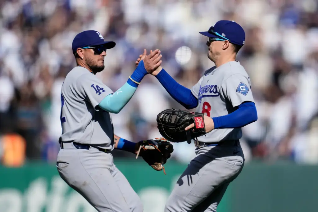 Dodgers third baseman Miguel Rojas, left, celebrates with first baseman...