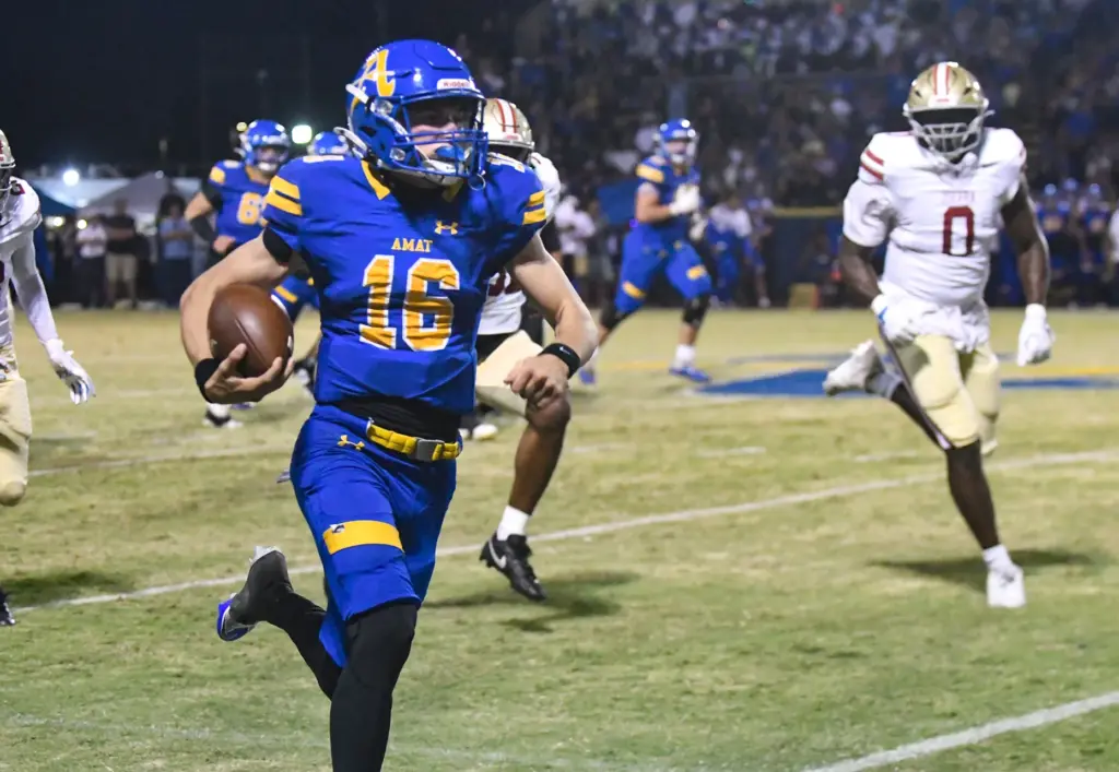 Bishop Amat quarterback Domenico Doran (16) runs away from JSerra...