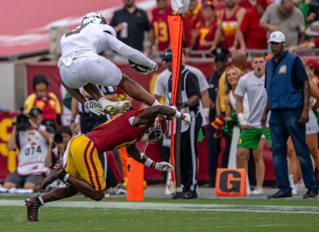 Oregon tight end Jamari Johnson (9) hurdles USC defender Kameryn...