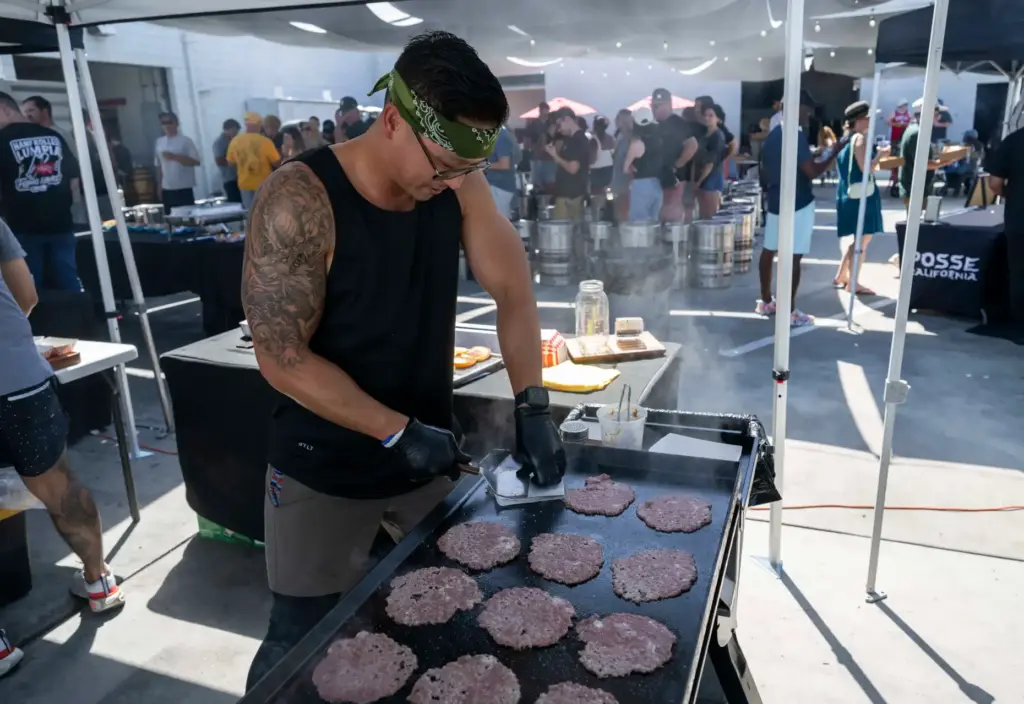 Jolly Dinh, co-owner of Jolly Burger, cooks up burgers at...