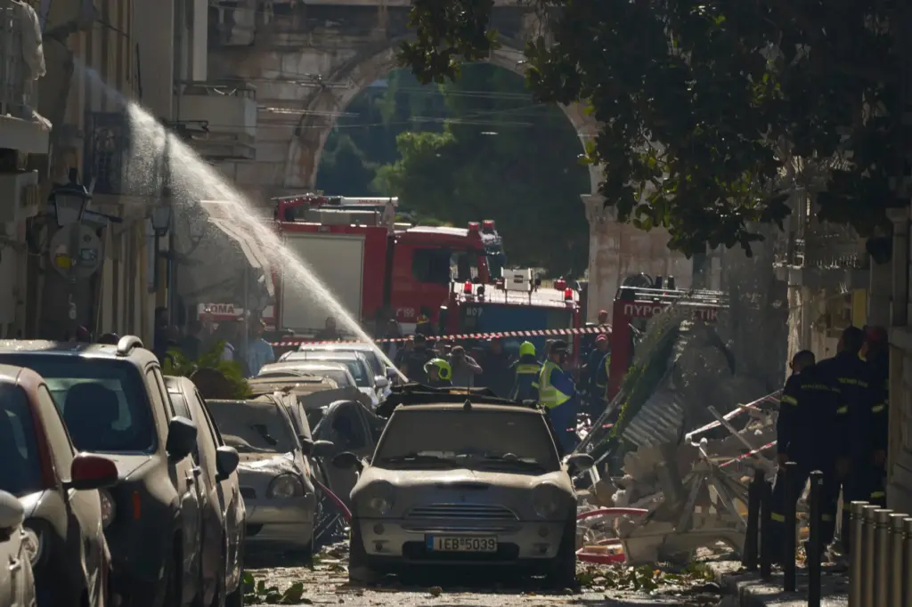 Firefighters work at the scene following a powerful blast that...