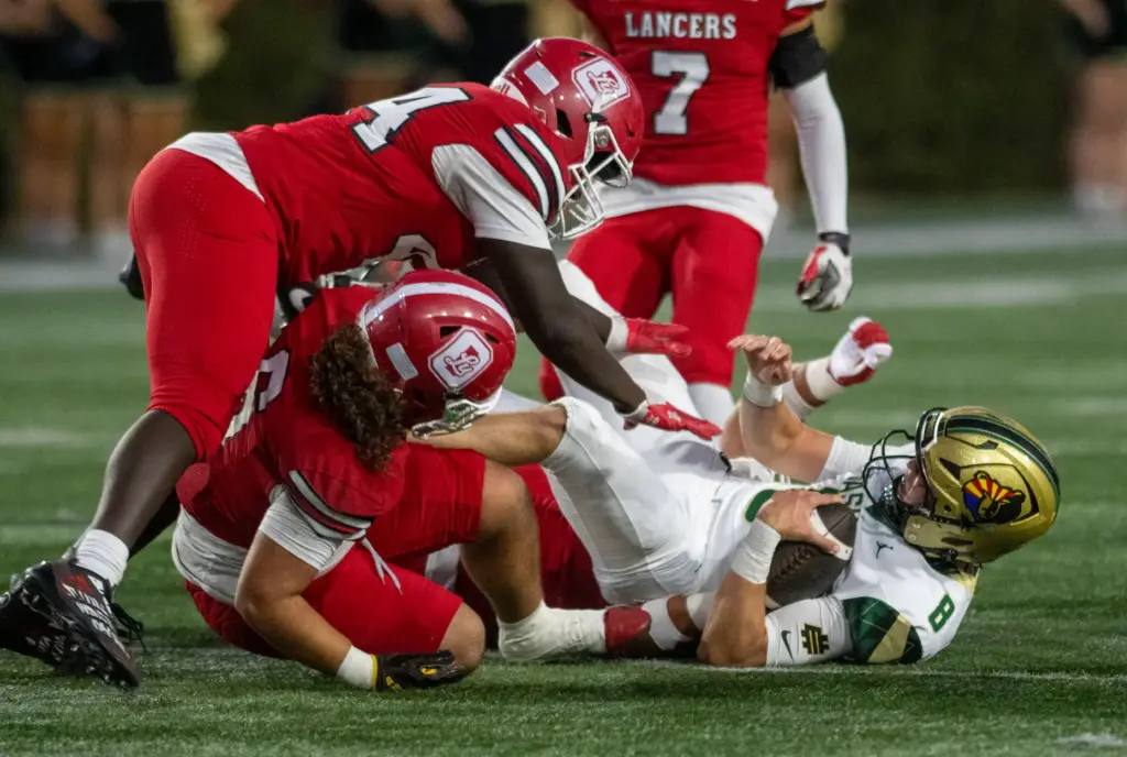 Orange Lutheranâs defense swarms Bashaâs Jake Rogers (8) during a...