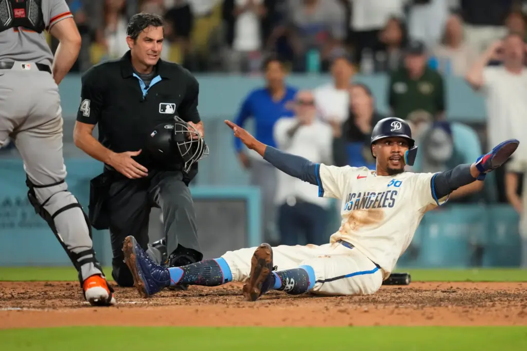 Dodgers’ Mookie Betts, right, gestures after being called out by...
