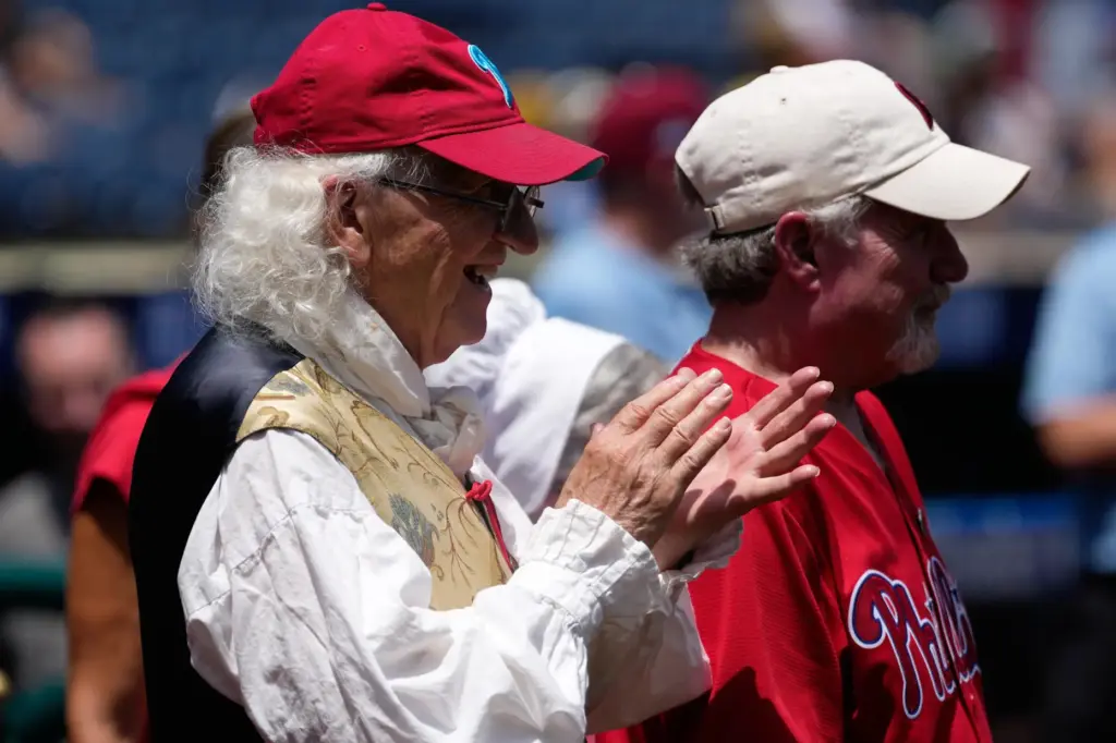 Bill Robling as Benjamin Franklin, left, cheers before a baseball...
