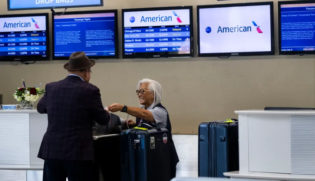 An American Airlines agent helps a customer at John Wayne...