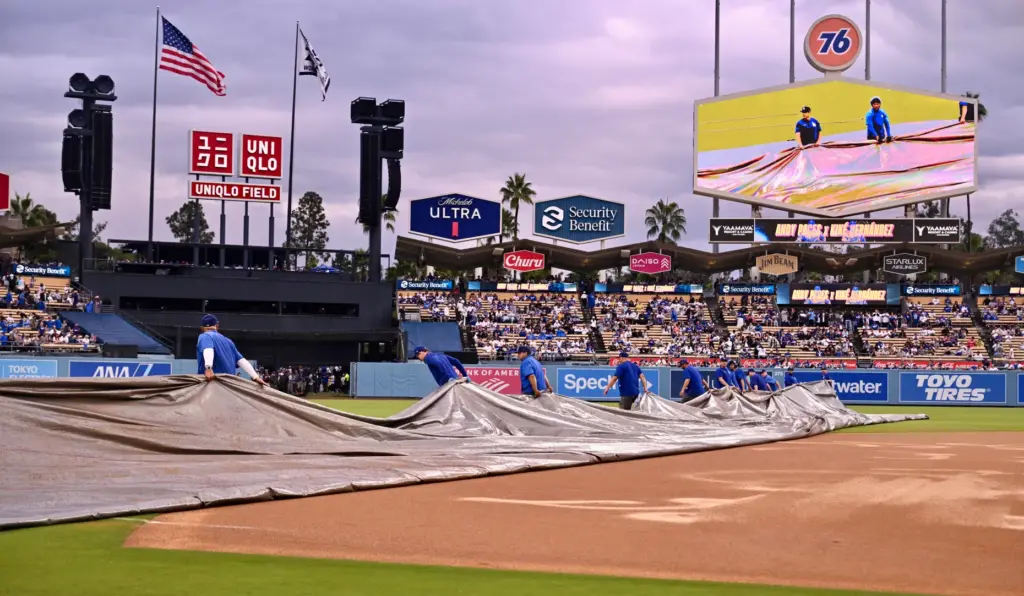 The Dodgers grounds crew removes the tarp from the field...