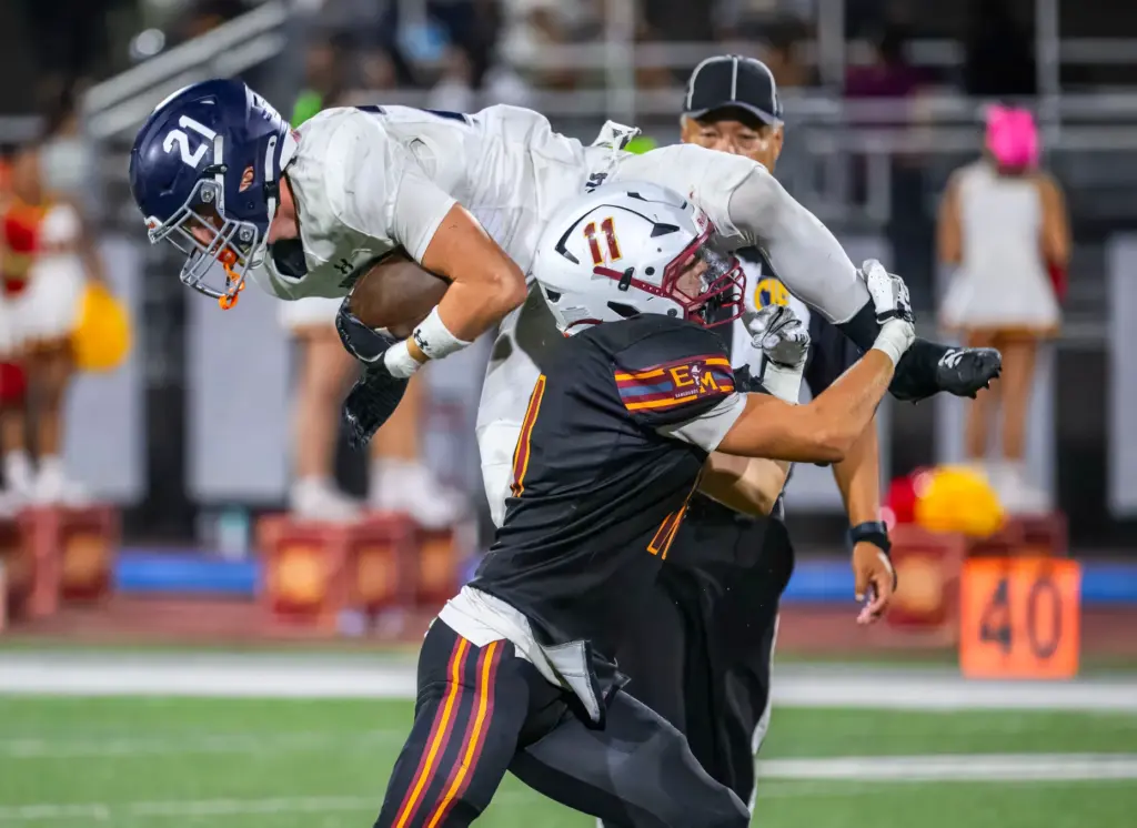 El Modena’s Aiden Sullivan, right, stops Trabuco Hills running back...