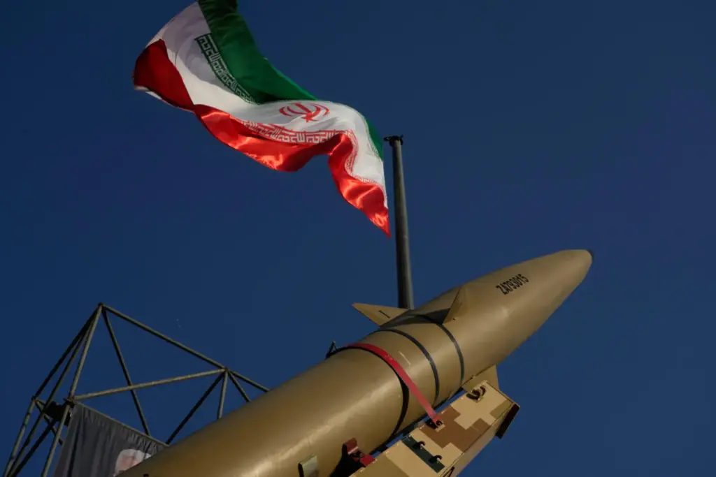 An Iranian missile is displayed under the country's flag.