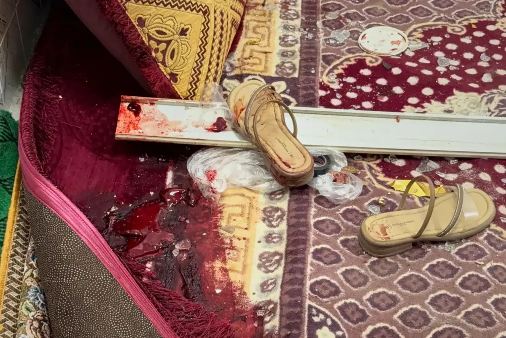 Blood stains are seen next to a pair of sandals...