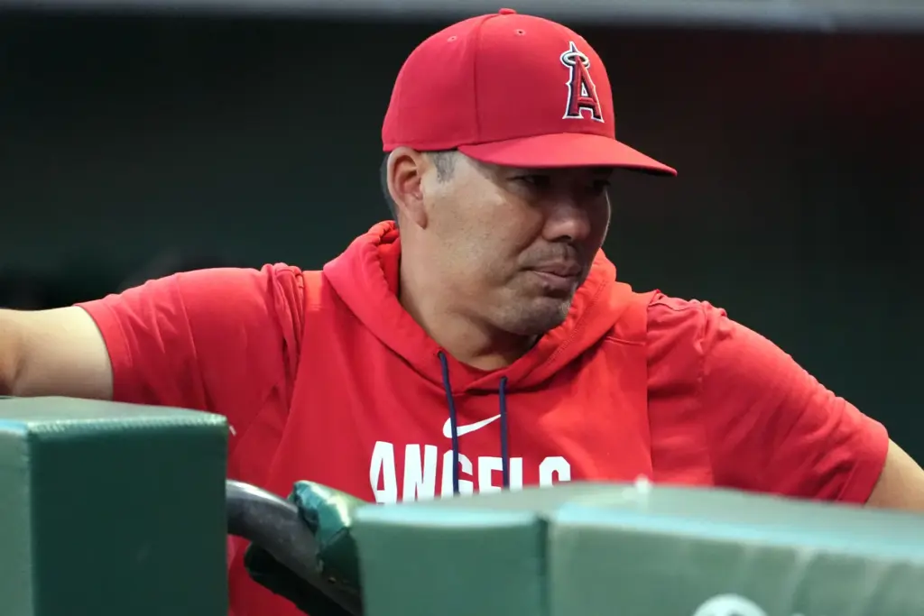 Angels manager Kurt Suzuki stands in the dugout during the...