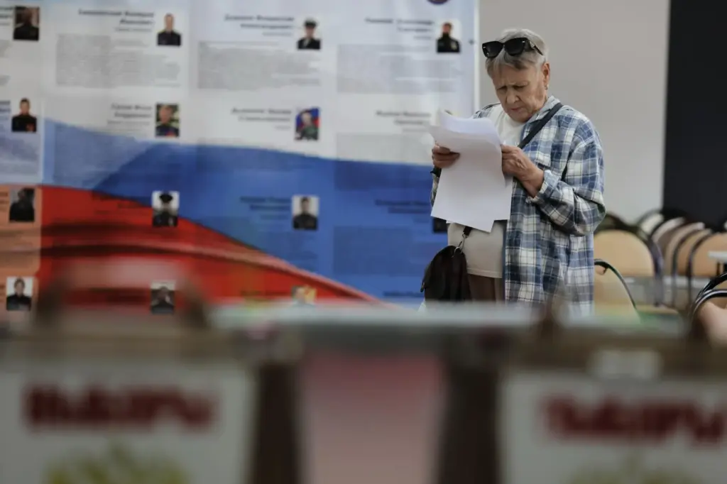 A voter holds her ballot prior to voting in the...