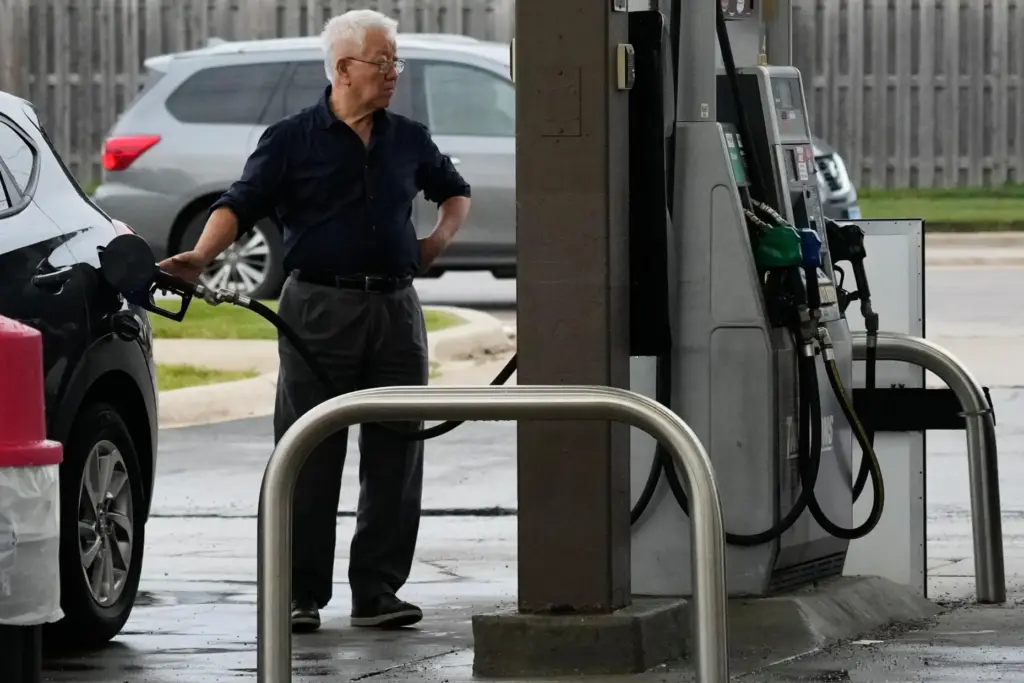 A customer checks gas price while he fills up his...