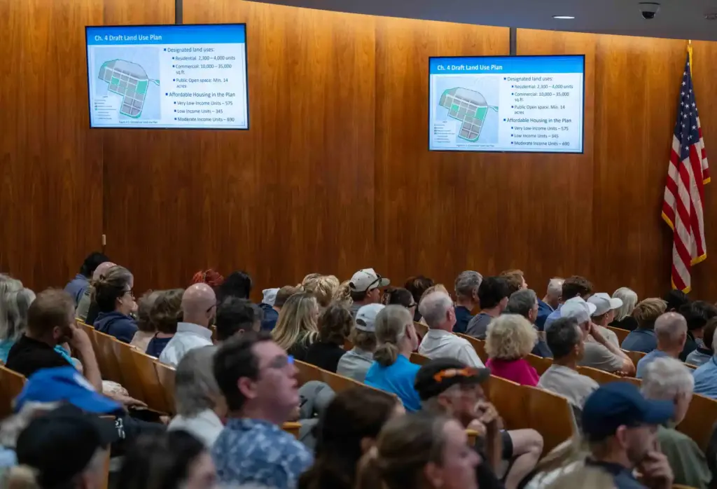 Members of the public listen in as the Costa Mesa...