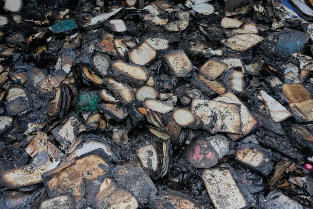 FILE – Burned books lie after a fire at the...