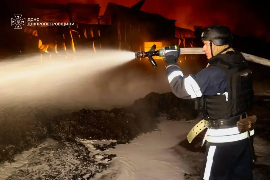 A rescue worker put out a fire of a infrastructure facility damaged after a Russian strike.
