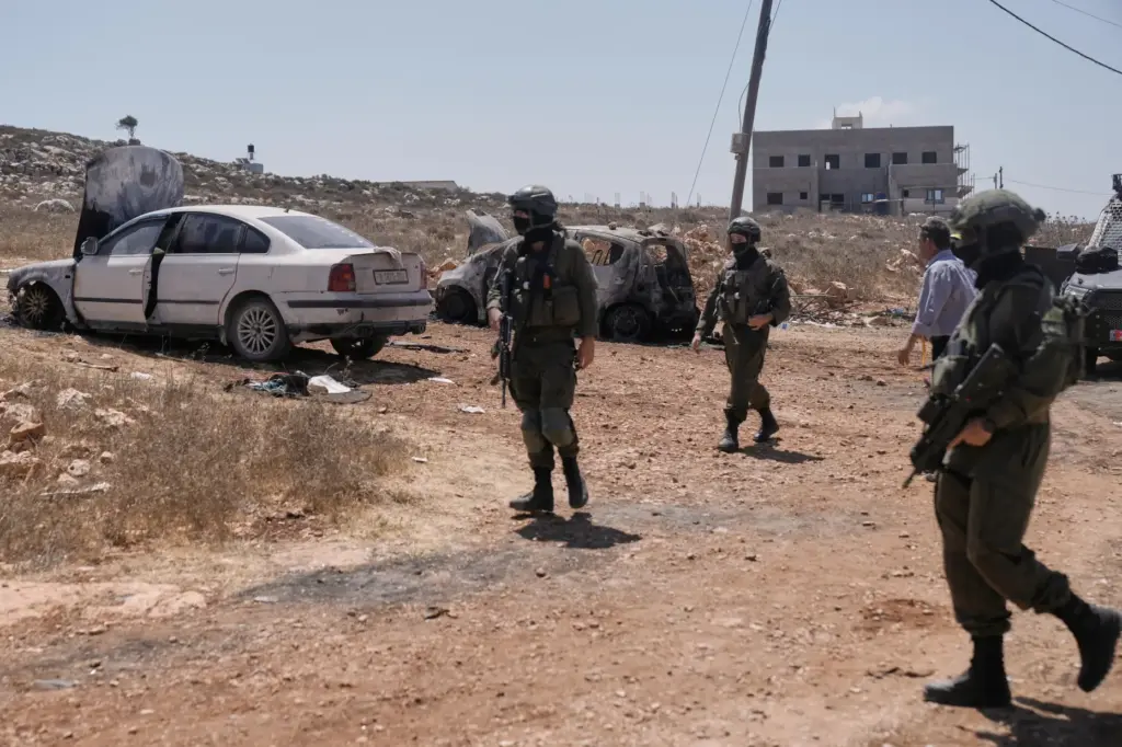 Members of the Israeli forces arrive at the site where cars were set on fire.