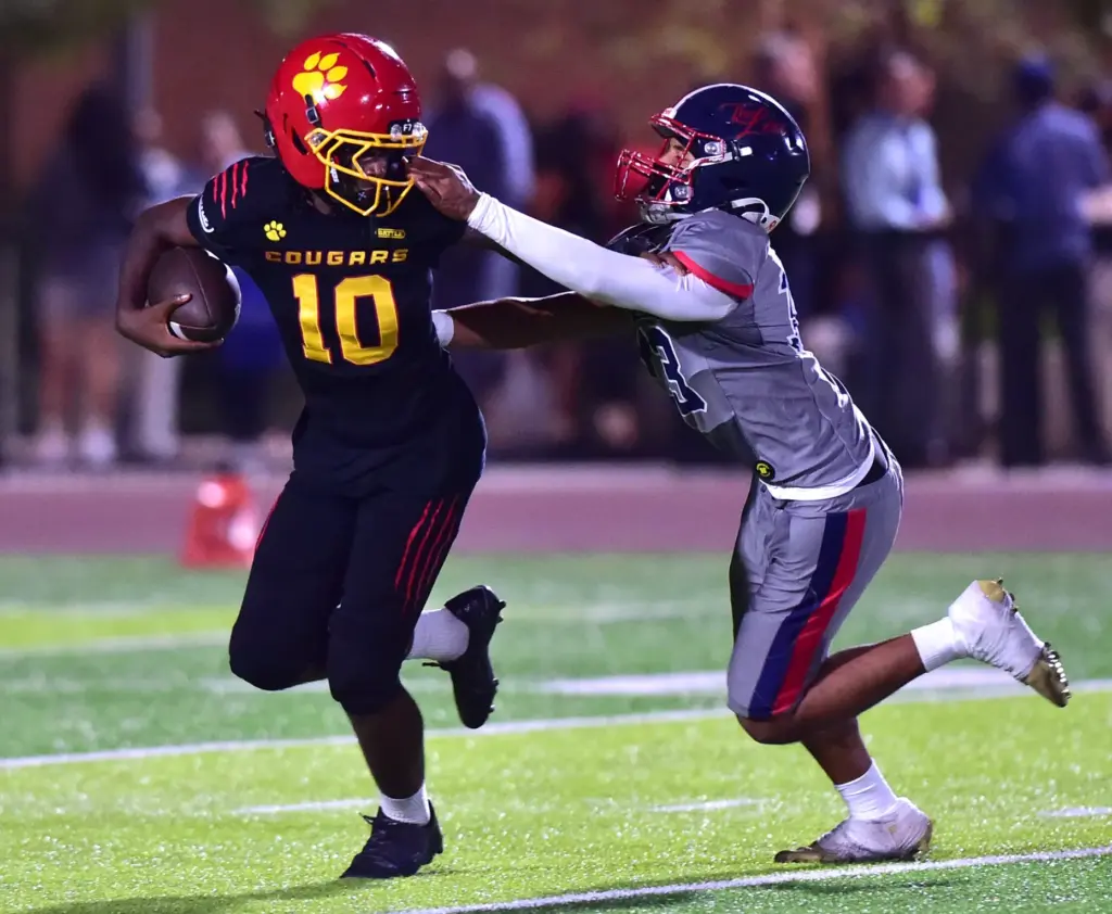 Hawthorne QB Daniel Green gets a facemask tug from Leuzinger’s...