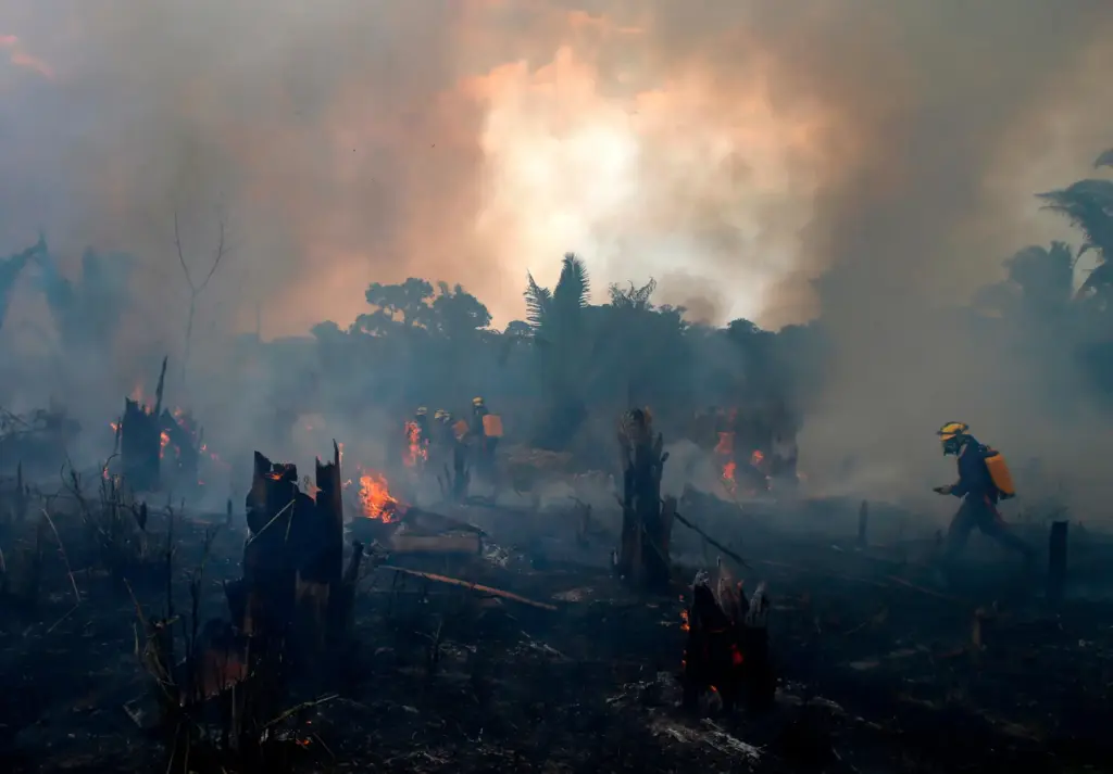 FILE – Fire brigade members work to put out a...