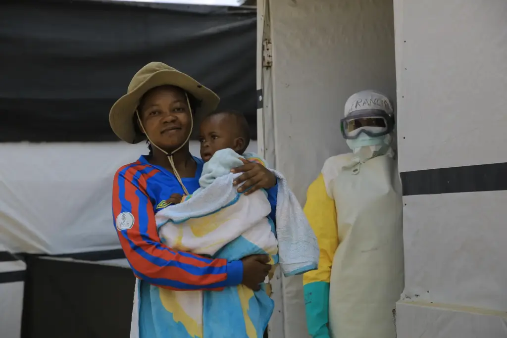 One-year-old Kavugho Mayolo Latifa, whose mother died of Ebola, is carried by her sister.