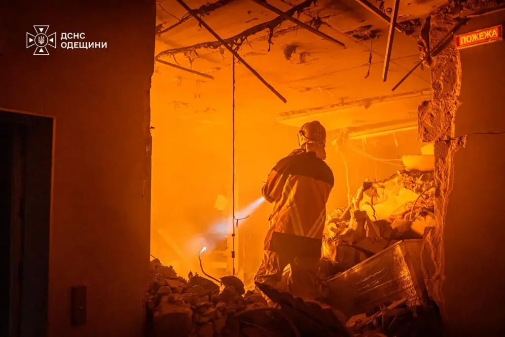 An emergency services personnel works to extinguish a fire following a Russian air attack.