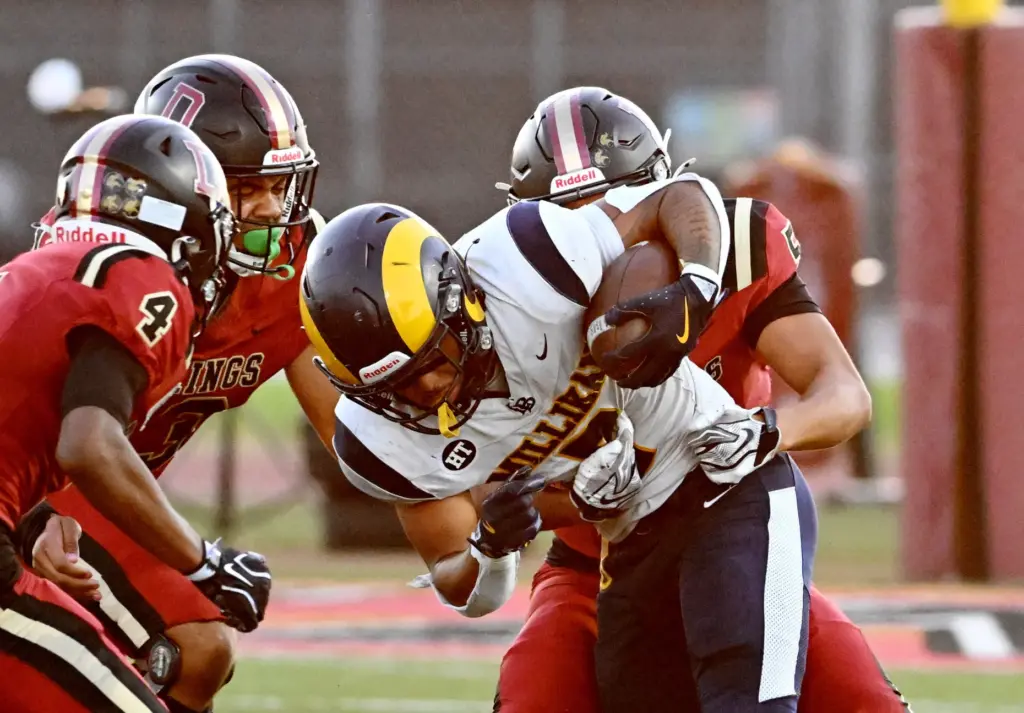 Millikan’s Ryan Carter (7) is tackled by Downey Vikings Mathew...