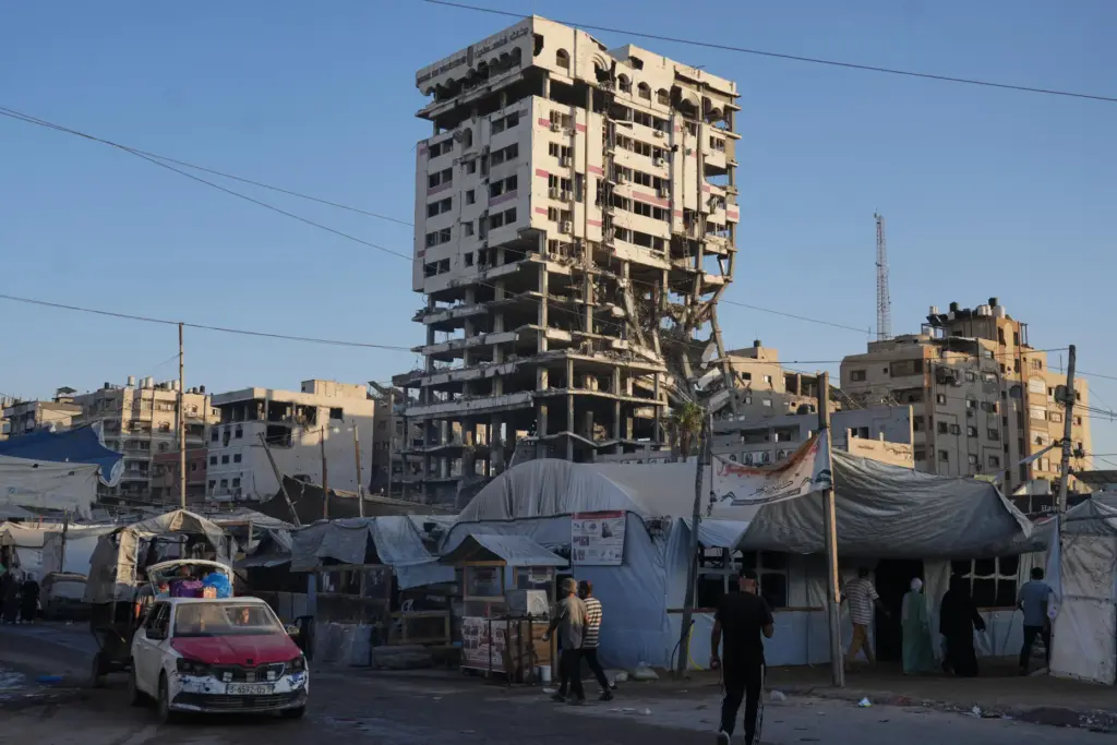 Tents sheltering displaced Palestinians and a market surround a building...