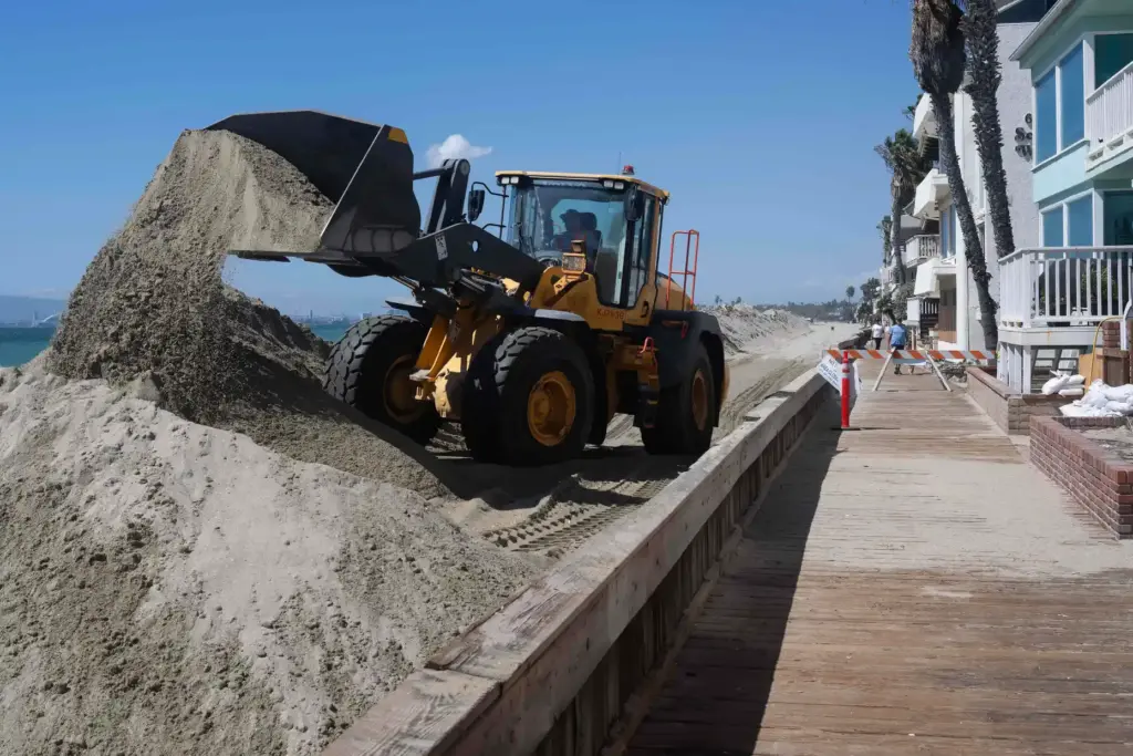 Crews work to reinforce vulnerable portions of the Long Beach...