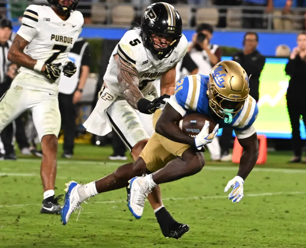 Running back Jaivian Thomas (21) of the UCLA Bruins runs...