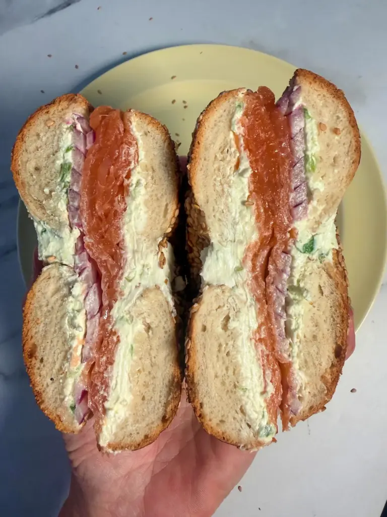 A bagel with smoked salmon, scallion cream cheese, and red...