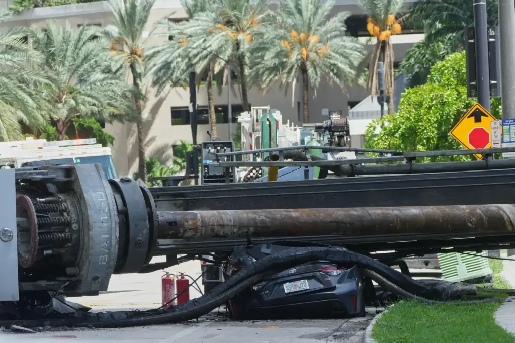 A large construction crane collapsed and crushed a car on...