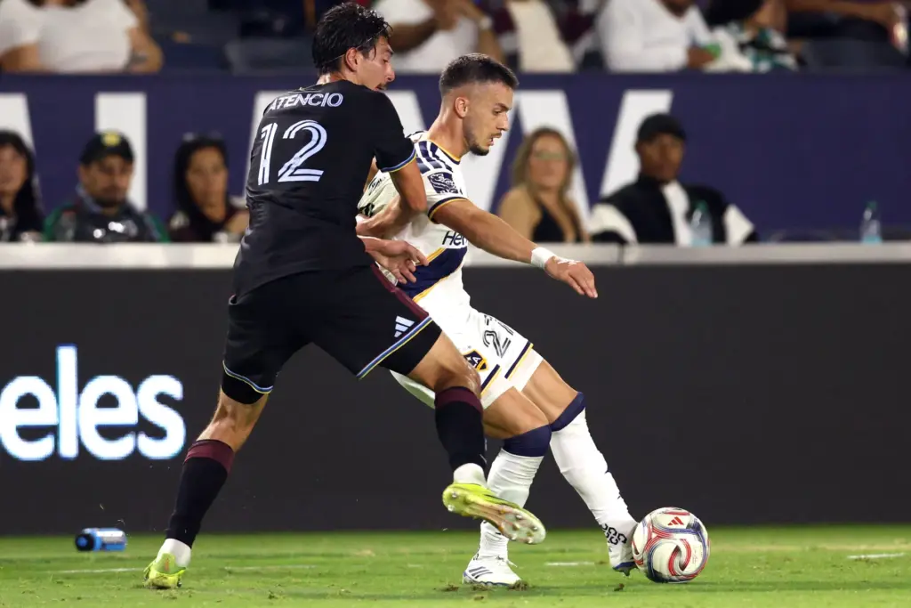 Galaxy midfielder Erik Thommy, right, is pushed by Colorado Rapids...