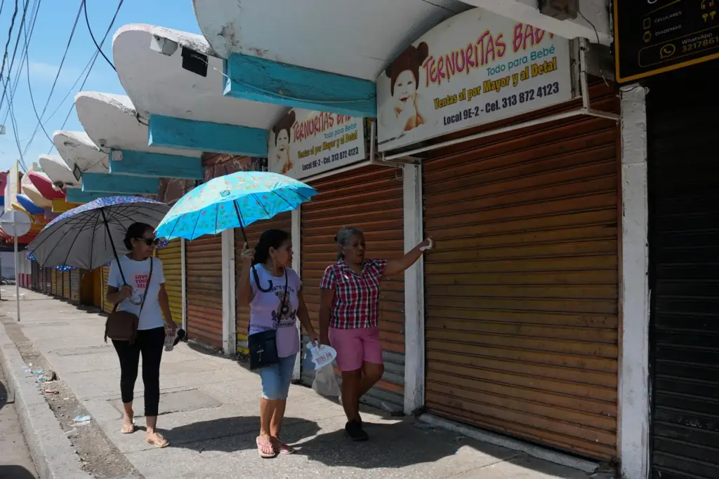 Women walk past shops that did not open due to...