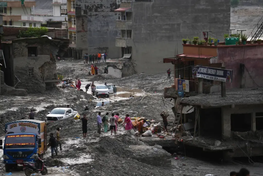 People salvage their belongings from a building damaged by flash flooding in Nepal.