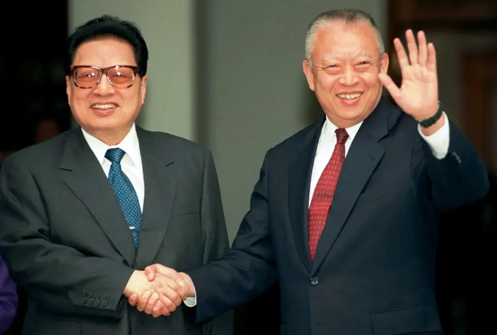 FILE – Hong Kong leader Tung Chee-hwa, right, waves to...
