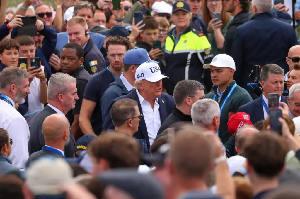 U.S. President Donald Trump makes his way through spectators as...