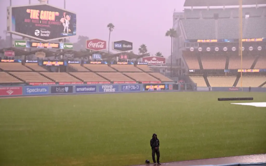 A lone Dodgers security officer stands on the field in...