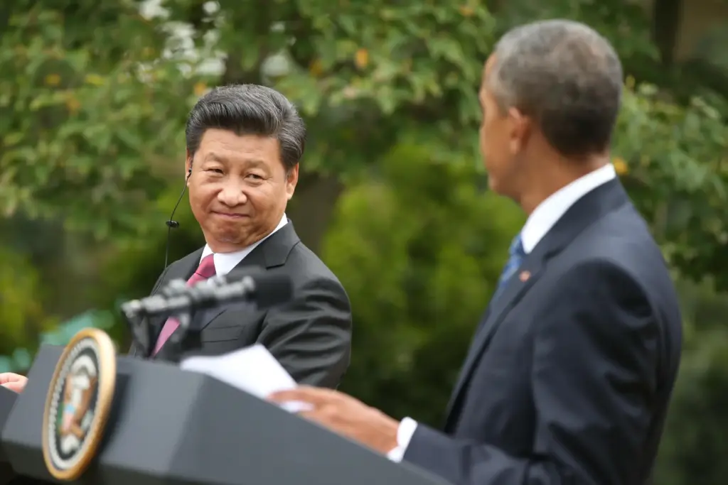 FILE – China’s President Xi Jinping looks toward President Barack...
