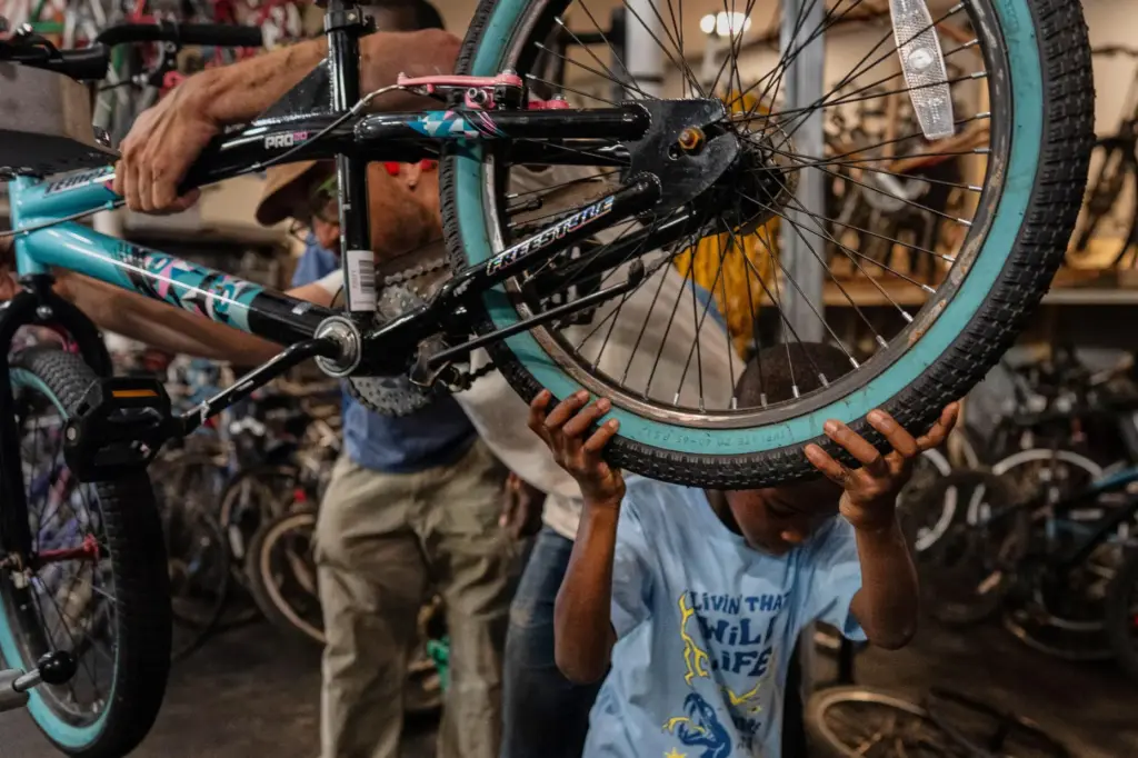 Vincent Wilson, left, who takes in donated, broken bikes and...