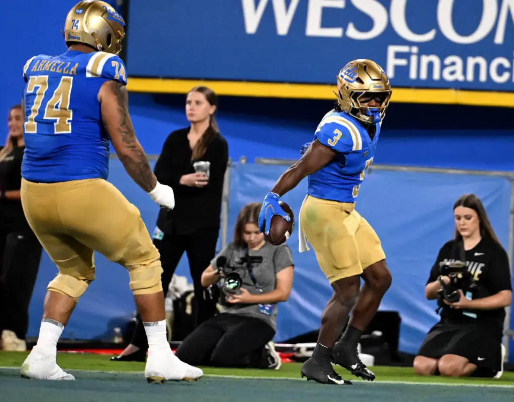 Running back Wayne Knight (3) of the UCLA Bruins runs...