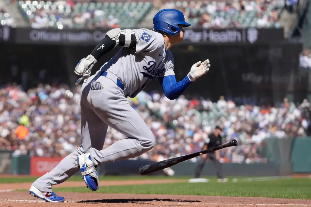 Dodgers designated hitter Shohei Ohtani runs to first base after...