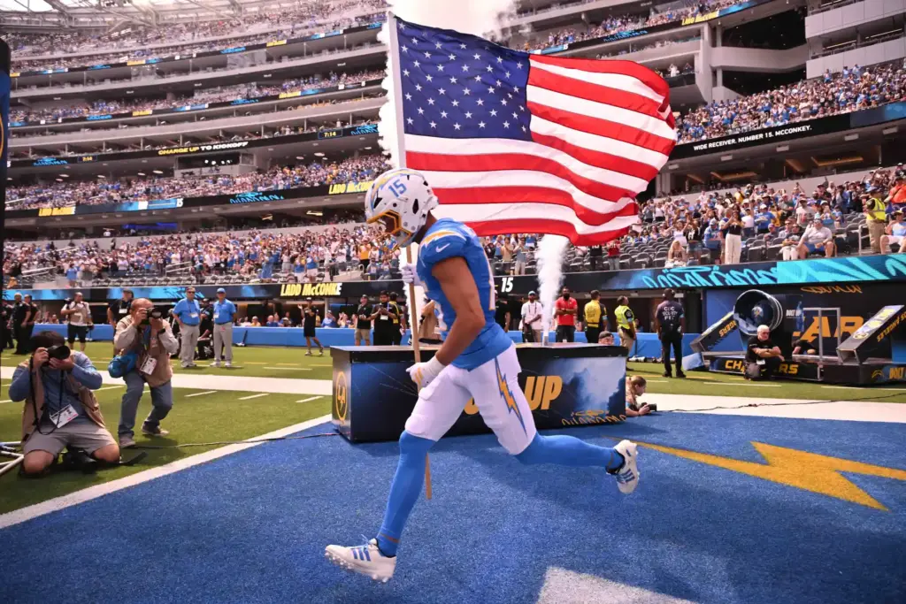 Chargers wide receiver Ladd McConkey (15) enters the field carrying...
