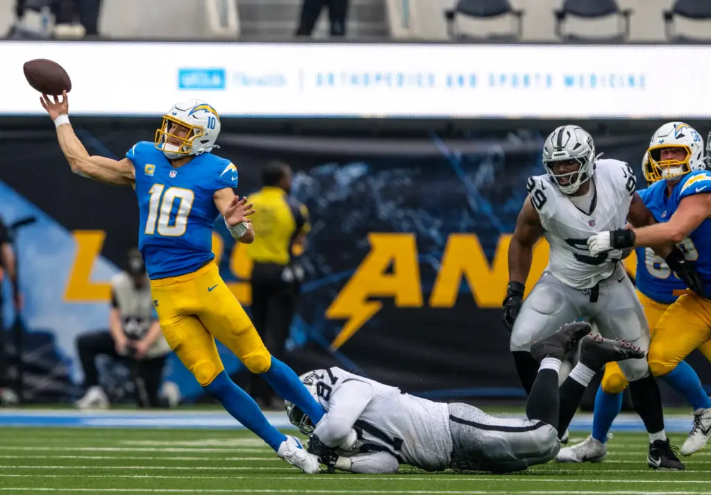 Chargers quarterback Justin Herbert (10) throws the ball before being...