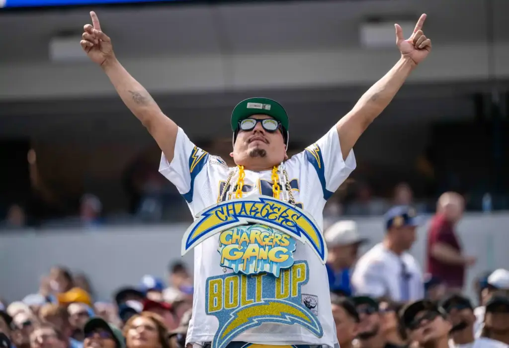 A fan cheers on the Chargers during a game against...